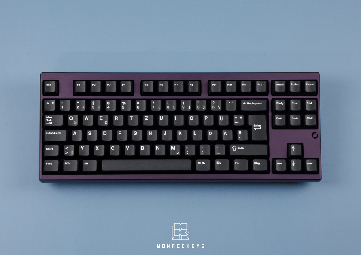 MK Essential White on Black Keycaps auf einer lila TKL-Tastatur, Draufsicht auf blauem Hintergrund
