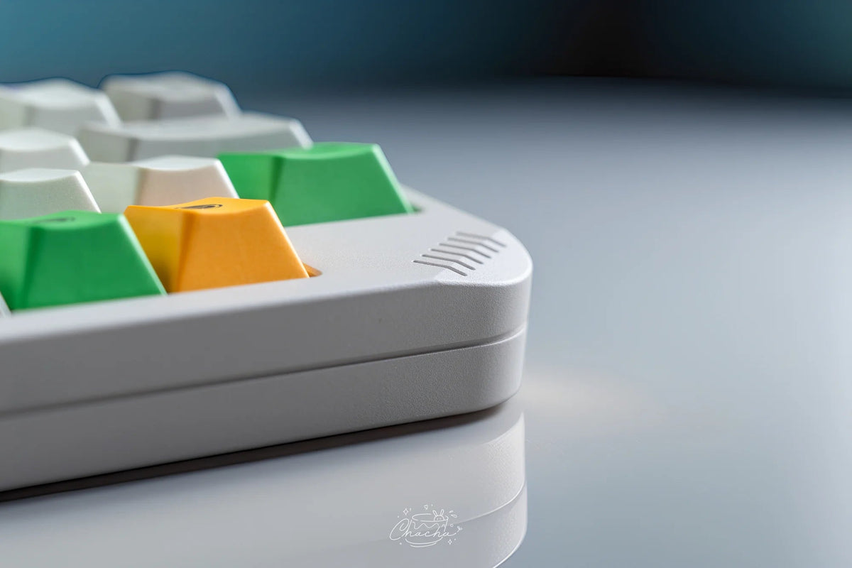 Niuniu KB40, weiße Case, Nahaufnahme der Ecke mit Lüftungsrippen und grünen und gelben Keycaps