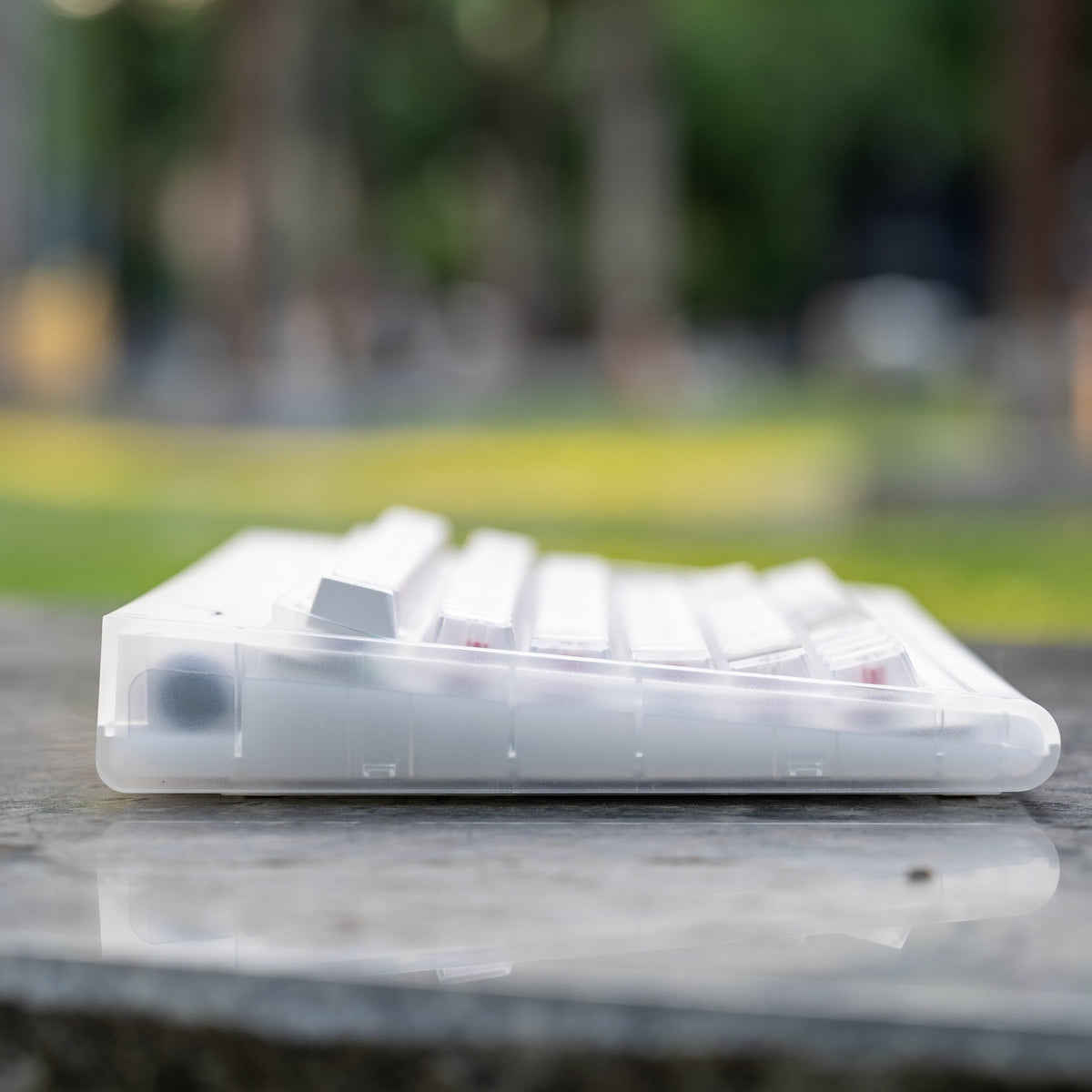 Smurve80 Lume Edition R2 in First Light, side profile of the curved case with a blurred park behind