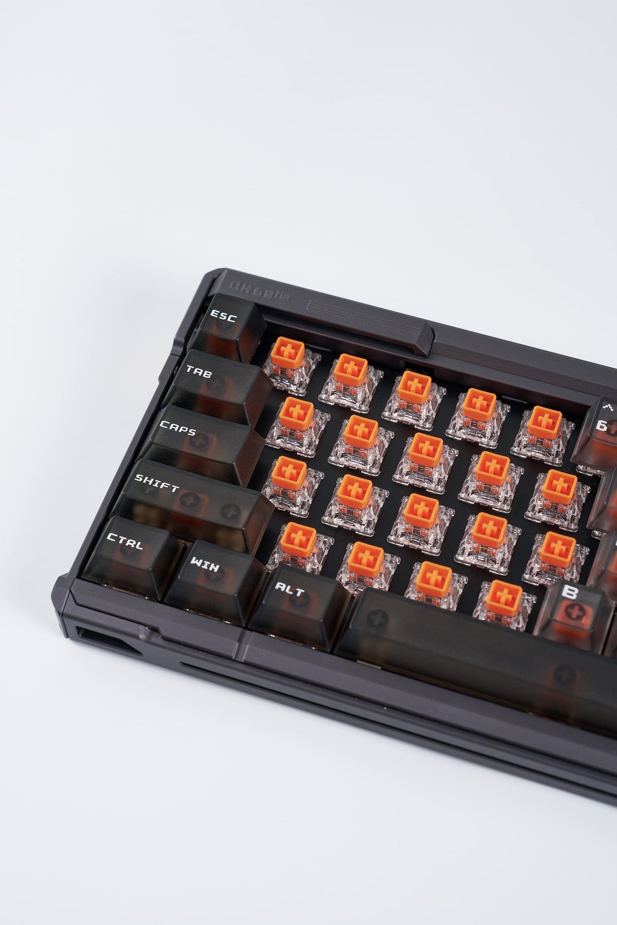 QK60 HE in Meteorite Grey, Nahaufnahme mit abgenommenen Keycaps und orangefarbenen Magnet-Switches