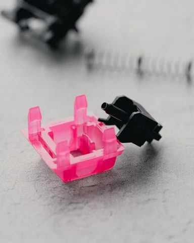Zerlegter F-ROW Hollow Tips Switch: pinkes Top-Housing, schwarzer Stem und Feder