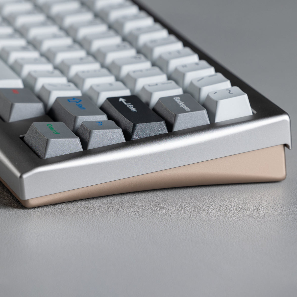 KBDFans KO-Onibi 60% keyboard kit, side view of the corner with a silver top case and gold-toned bottom case