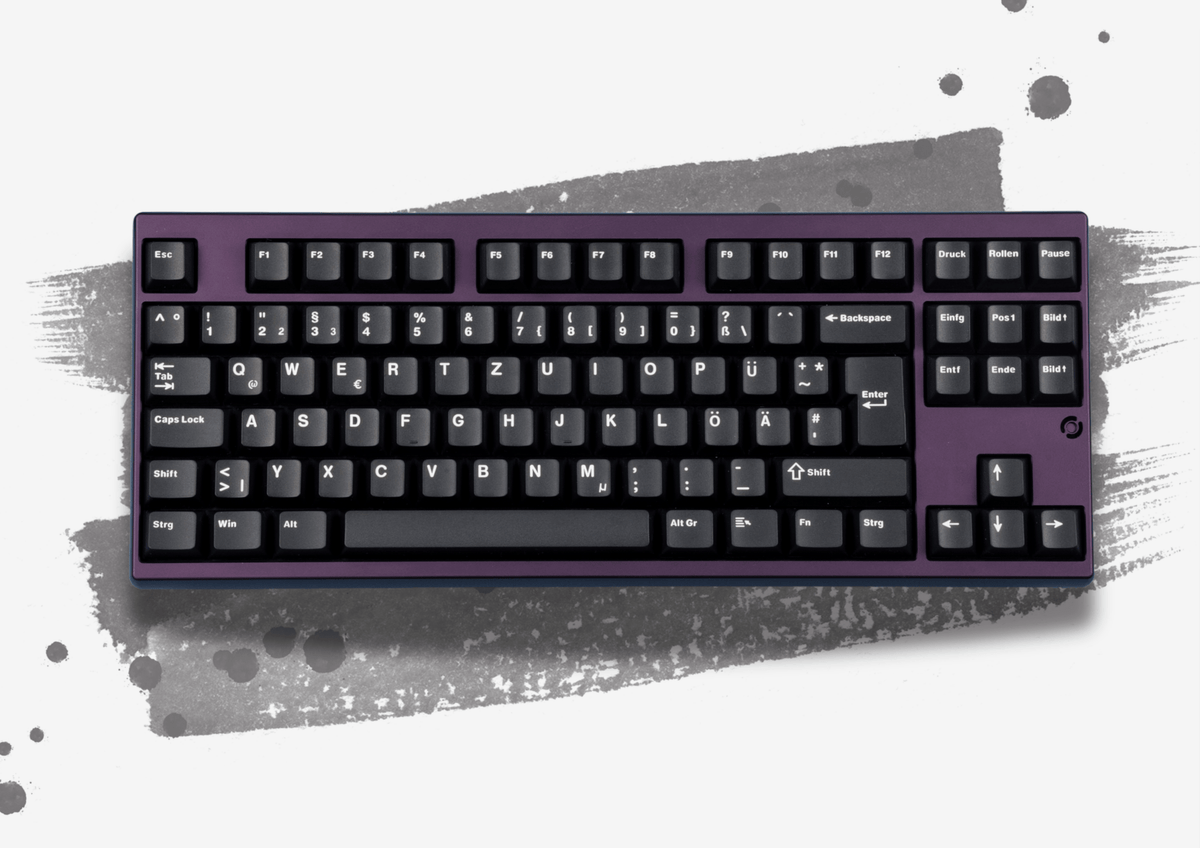 MK Essential White on Black Keycaps auf einer lila TKL-Tastatur, Draufsicht vor grauem Pinselstrich, ISO-DE