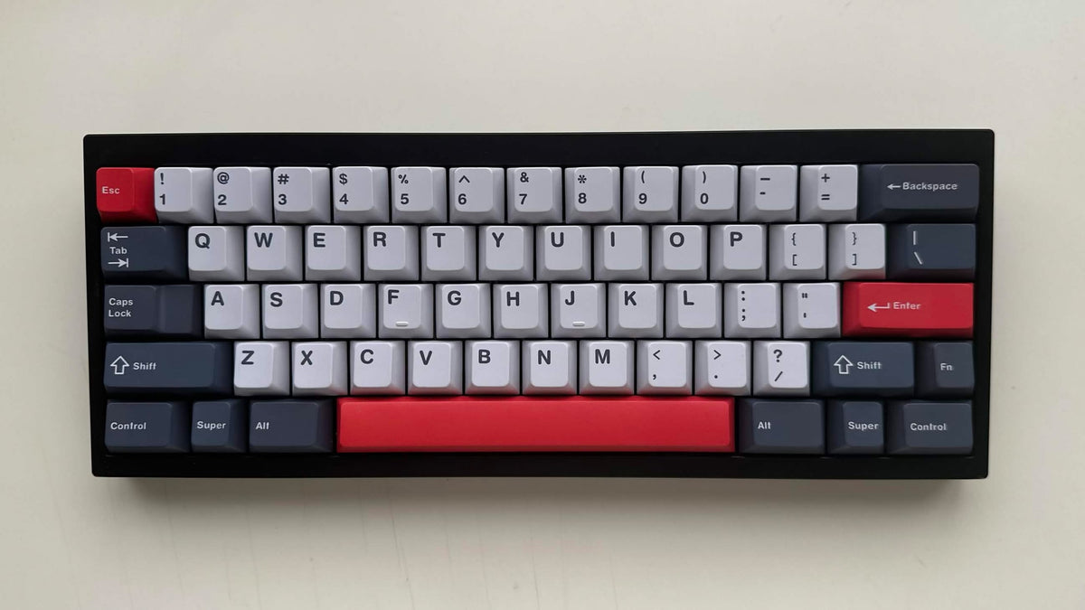 MW Datenshi Keycap Set (Sample) auf einer schwarzen 60%-Tastatur von vorn: Off-White, Dunkelgrau und Rot