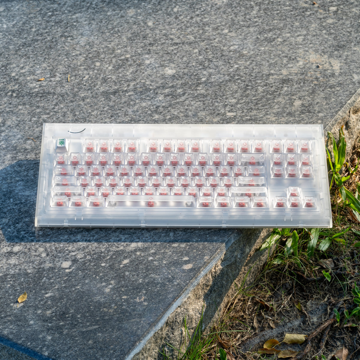 Smurve80 Lume Edition R2 in First Light with pink switches on a stone slab next to grass